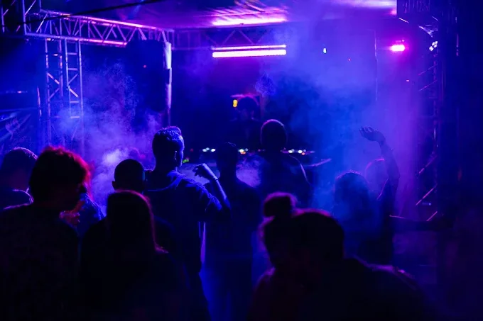 Tanzendes Publikum in blauem und violettem Licht vor der Beach Stage beim RAW Festival, Nebel und Traversen über der Bühne